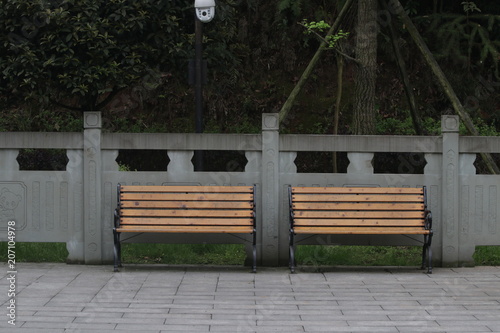 Fototapeta Naklejka Na Ścianę i Meble -  Wood Benches  along the foot path  for taking a rest in the Park