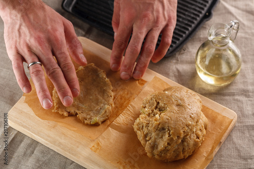 man sculpts hands dough for flat bread on the background of the grill