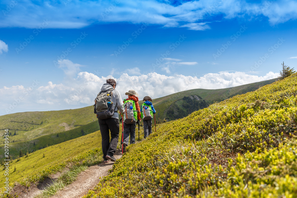 Hiking woman with her children in Romanian mountains