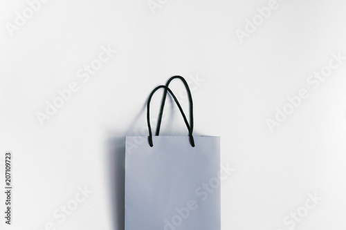Paper bag on grey background. Flatlay, top view. Shopping concept