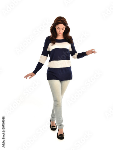 full length portrait of girl wearing striped blue and white jumper and jeans. standing pose on white studio background © faestock