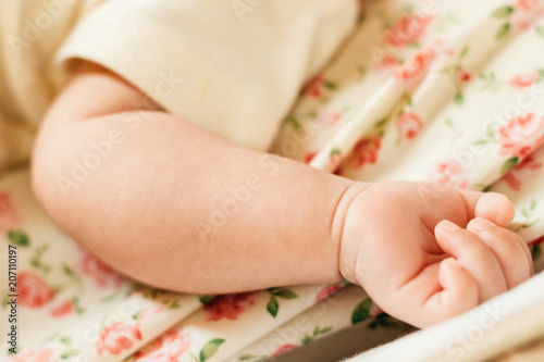 Baby hand on her bed.