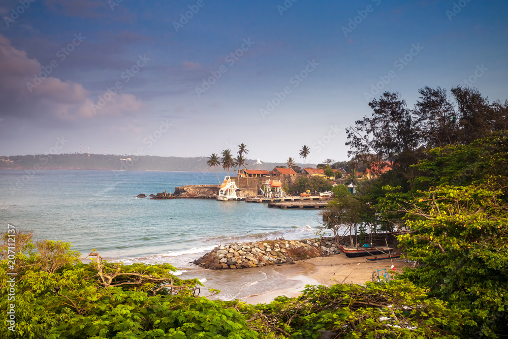 Stunning panoramic view of Unawatuna, the coastal town in Galle district, Sri Lanka. The traditional houses surrounded by the tropical forest next to the bay. Ideal place for rest and relax.