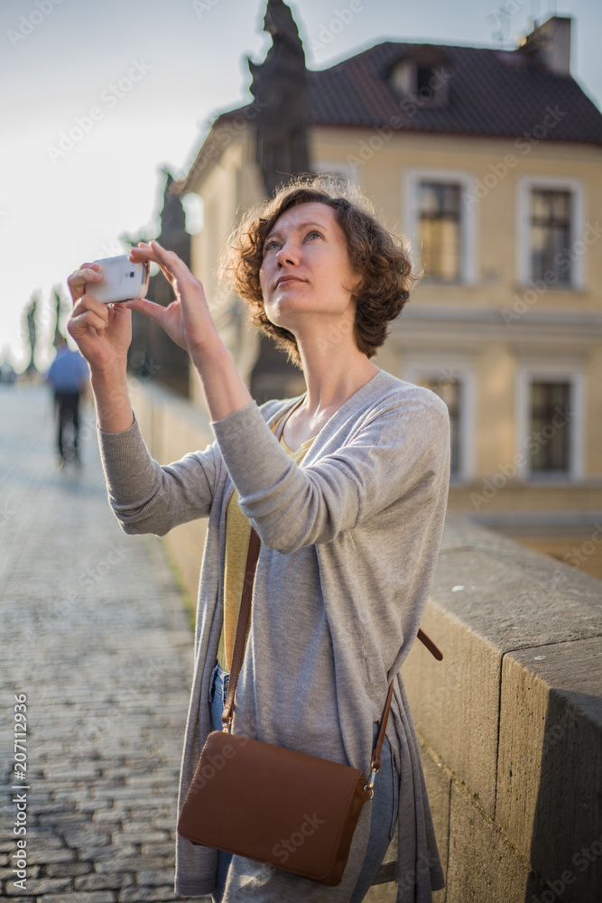 A tourist woman walks along the Charles Bridge in Prague in the summer. Prague, Czech Republic