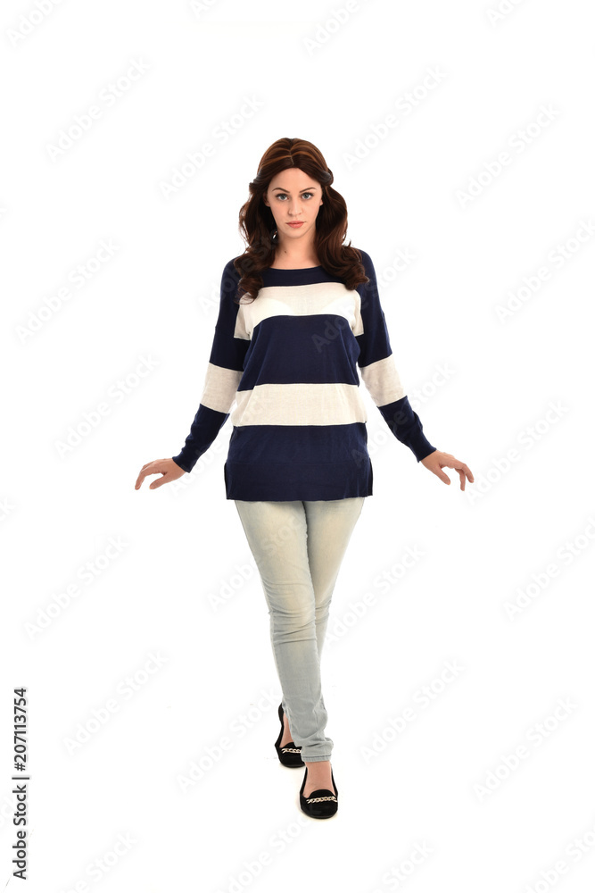 full length portrait of girl wearing striped blue and white jumper and jeans. standing pose on white studio background full length portrait of girl wearing striped blue and white jumper and jeans. standing pose on white studio background