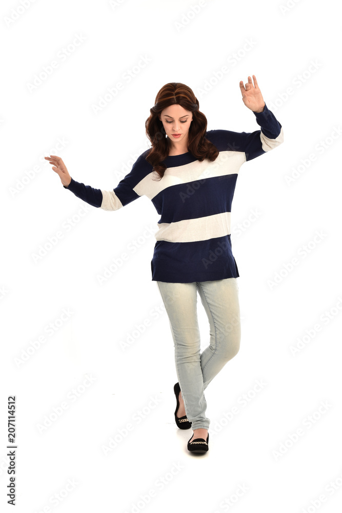 full length portrait of girl wearing striped blue and white jumper and jeans. standing pose on white studio background