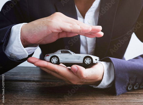 Car insurance concept, Hand man protect a car on the table..