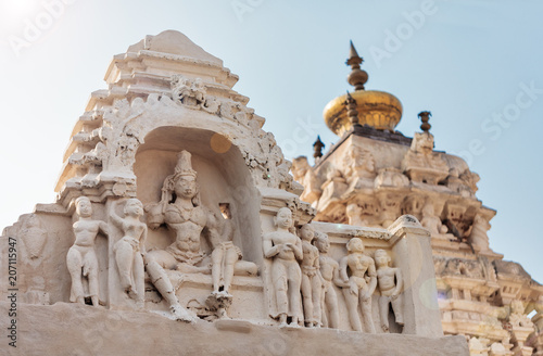 View of deity`s, roofs and tops of the Virupaksha temple complex against the background of the blue sky.  photo