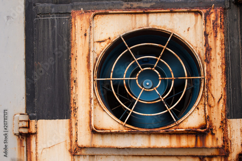 spinning fan on a rusty wall