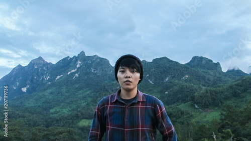 Asian young man in Scottish shirt and black hat hiking at mountain peak above clouds and fog Hiker outdoor. Doi Luang Chiang Dao Chiang Mai Province,In morning. photo