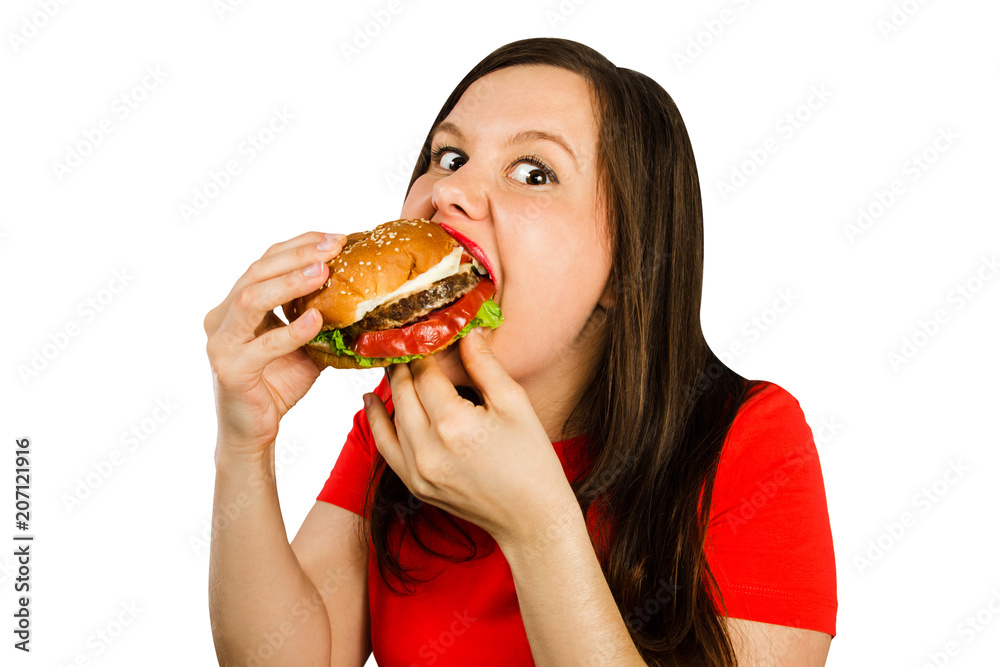 Young woman holds hamburger and eats him, isolated on white background. Looks in camera. Young woman holds hamburger and eats him, isolated on white background. Looks in camera.
