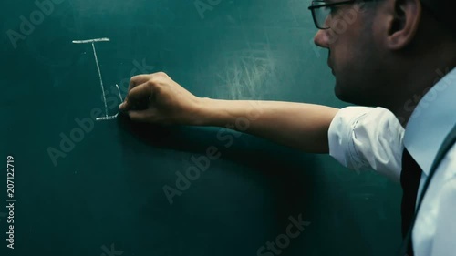 mprovement. The businessman in glasses is writing on the blackboard photo