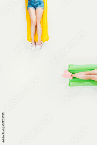 cropped shot of people lying on inflatable mattresses and relaxing isolated on white