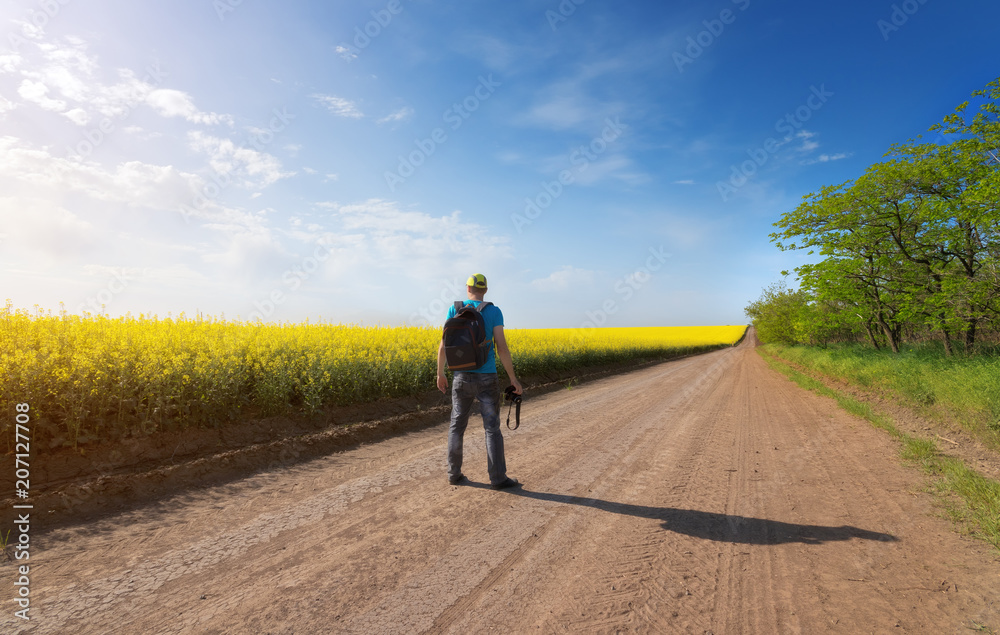 Obraz premium photographer in search of a story / photo hike rapeseed field story search