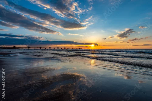 Obraz odbicie chmur w mokrym piasku podczas zachodu słońca