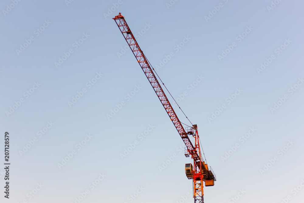 Red construction crane against clear, bright blue sky - development in the city- copy space, design element Red construction crane against clear, bright blue sky - development in the city- copy space, design element