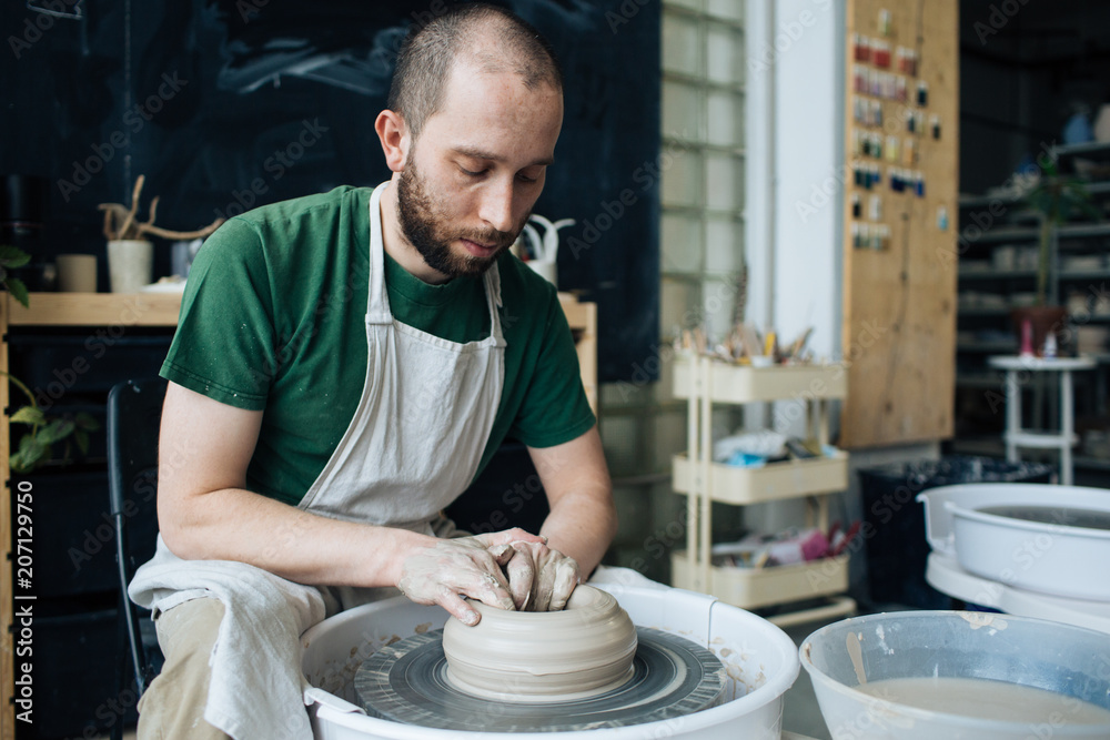 Handcrafted on a potter's wheel,Hands make clay from various items for home and sale in the store and at the exhibition, ceramic items are made in hand, stylish bearded young man makes products Handcrafted on a potter's wheel,Hands make clay from various items for home and sale in the store and at the exhibition, ceramic items are made in hand, stylish bearded young man makes products
