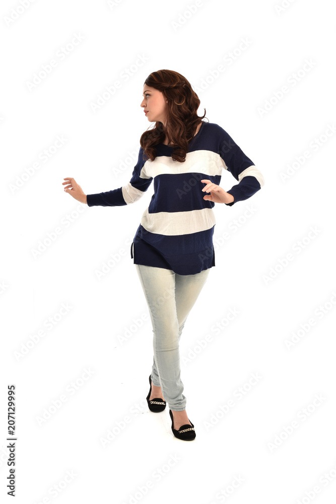 full length portrait of girl wearing striped blue and white jumper and jeans. standing pose on white studio background full length portrait of girl wearing striped blue and white jumper and jeans. standing pose on white studio background