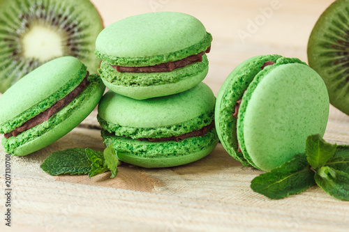 Green french macarons with kiwi and mint decorations