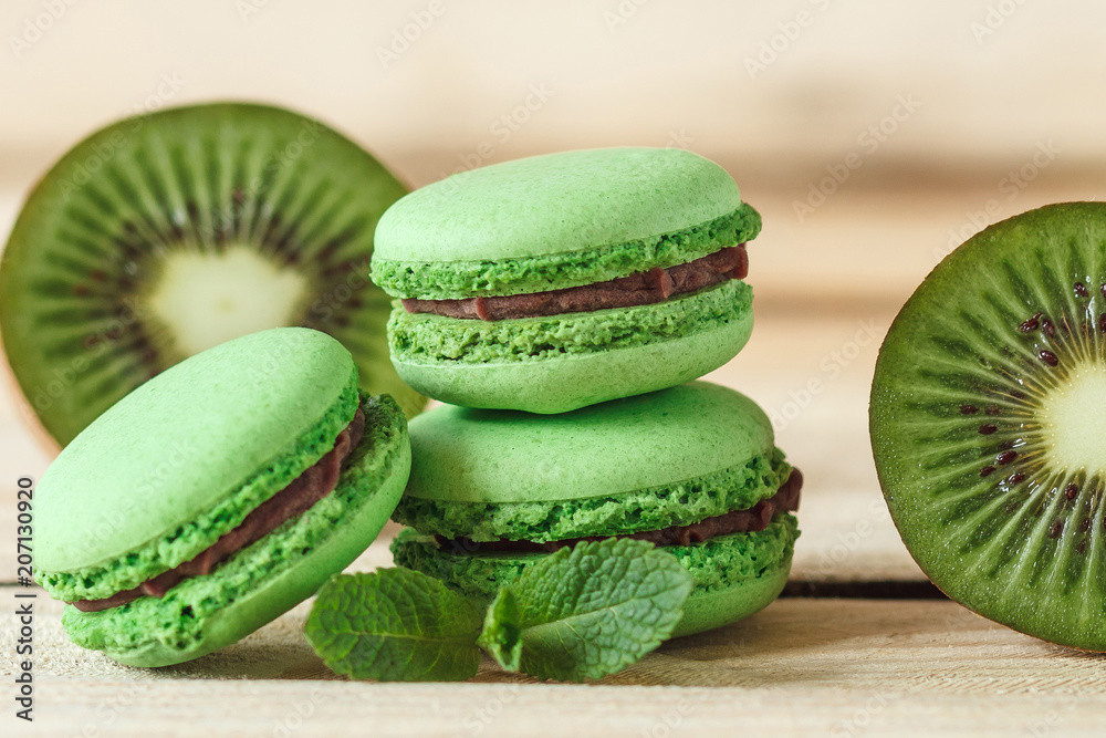 Green french macarons with kiwi and mint decorations Green french macarons with kiwi and mint decorations
