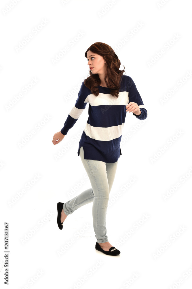 full length portrait of girl wearing striped blue and white jumper and jeans. standing pose on white studio background full length portrait of girl wearing striped blue and white jumper and jeans. standing pose on white studio background