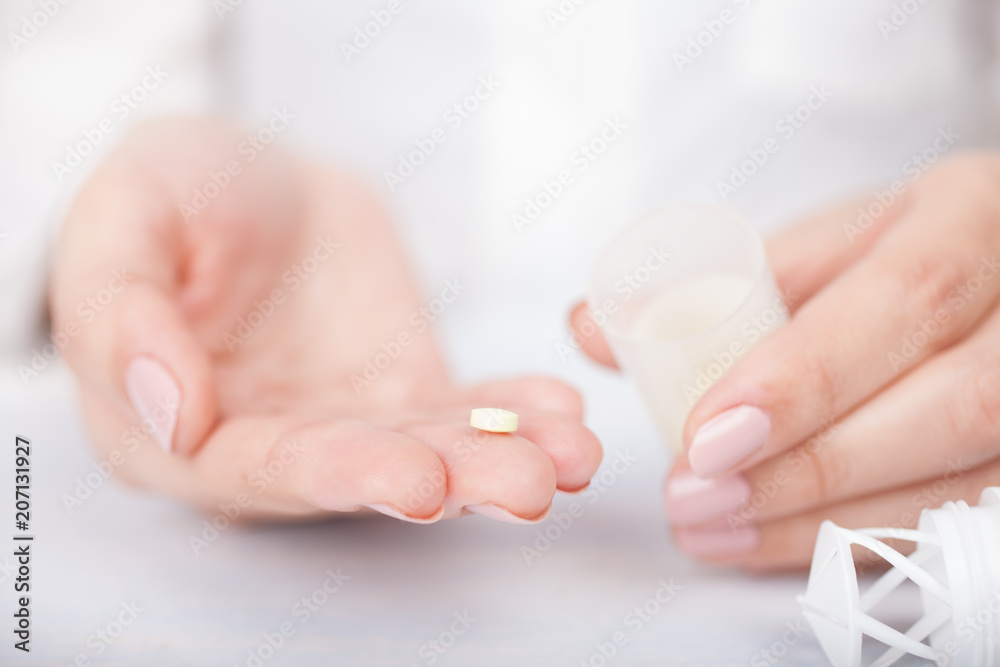 woman's hands with pills
