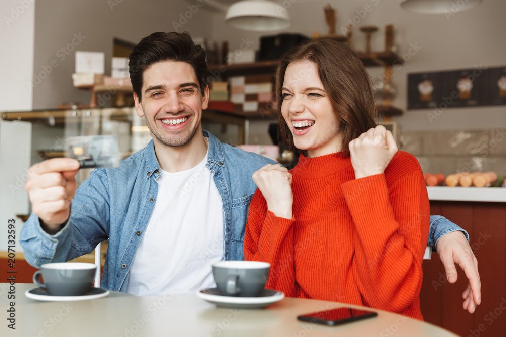 Happy young couple sitting at the cafe table Happy young couple sitting at the cafe table