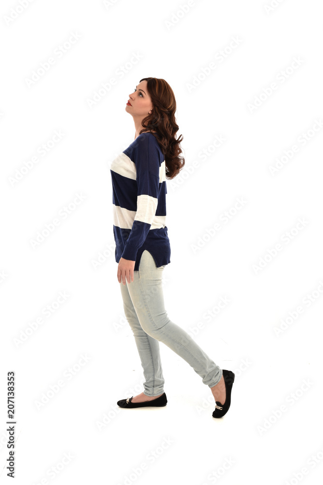full length portrait of girl wearing striped blue and white jumper and jeans. standing pose on white studio background full length portrait of girl wearing striped blue and white jumper and jeans. standing pose on white studio background