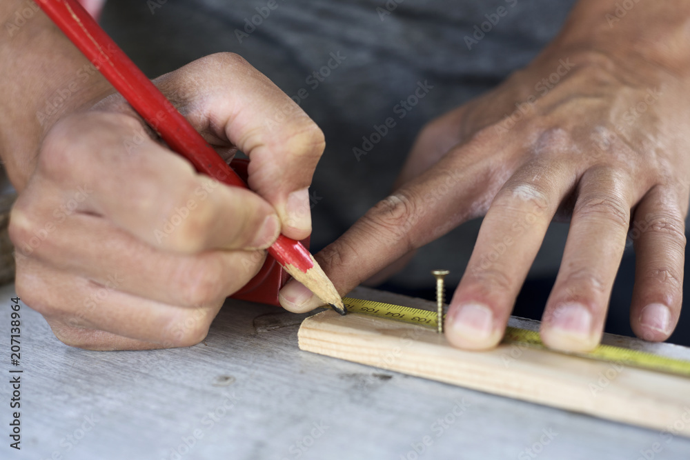 Obraz premium young man making a mark in a wood strip