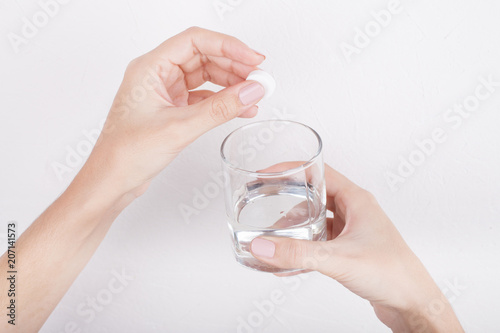 Hand with pills and glass of water