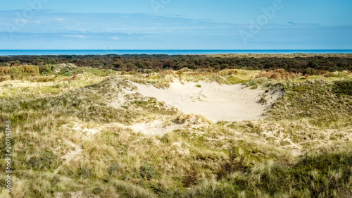 Standing on a hill above the dunes and forests on the Dutch Wadden Isle of Schiermonnikoog  we can see the Wadden Sea in the distance. Photo was shot in September.