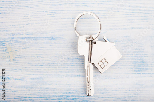 House key with trinket house on a wooden background