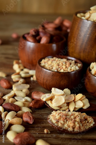 Whole and shredded peanuts in wooden bowls