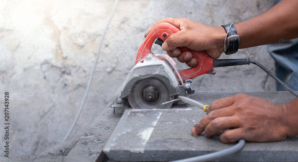 Close up of worker making cut sandstone by electric hand stone saws, working with power tools
