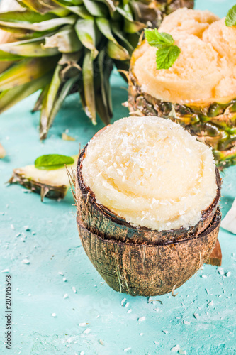 Summer holiday vacation concept, set various tropical ice cream sorbets, frozen juices in pineapple, grapefruit and coconut, light blue concrete background copy space
