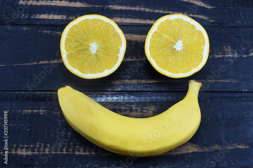 orange and banana lie on the table in the form of a smile