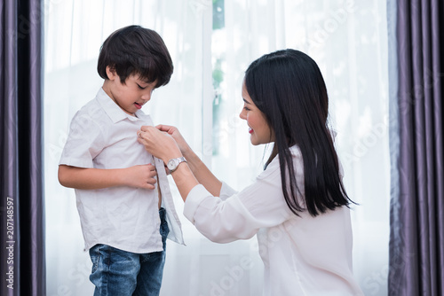Foto Young Asian mom dressed up son outfits for preparing go to school