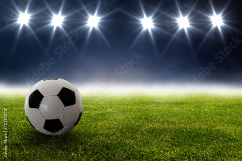 Fototapeta Naklejka Na Ścianę i Meble -  Fußball vor Strahlern auf dem Rasen im Stadion