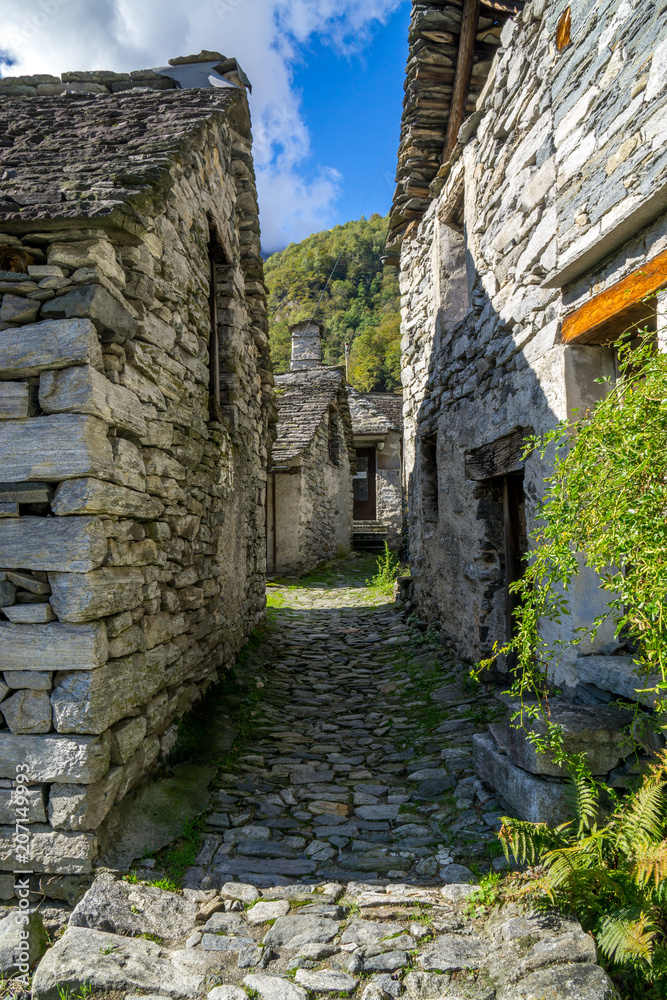 path between two stone buildings old village