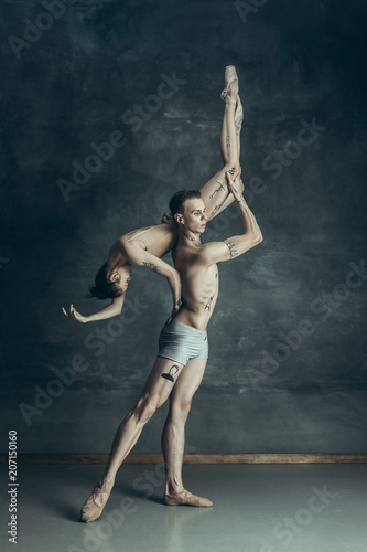The young modern ballet dancers posing on gray studio background