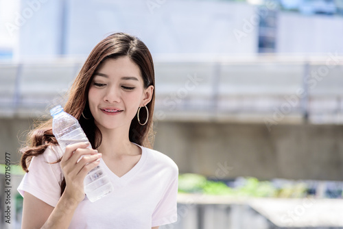 Photography Asian beautiful woman has water drinking with city background in the morning