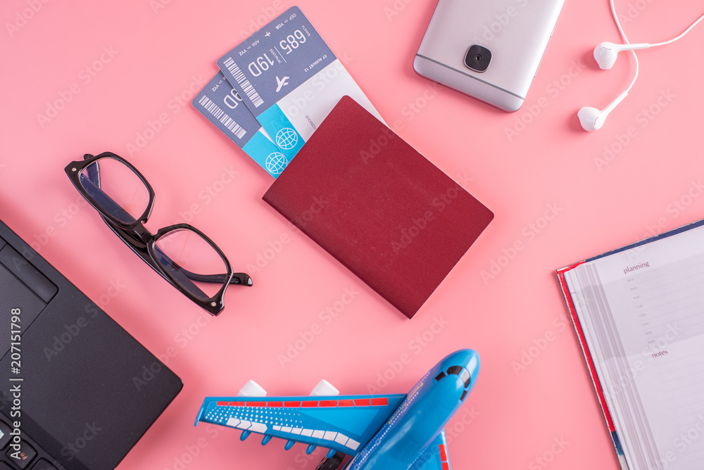 Plane, air tickets, passport, notebook and phone with glasses on pink background. The concept of planning for travel Plane, air tickets, passport, notebook and phone with glasses on pink background. The concept of planning for travel