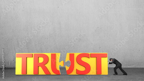 Man push puzzle pieces with word TRUST together