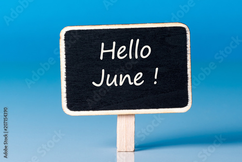 Hello June - text on little wooden tag at blue background