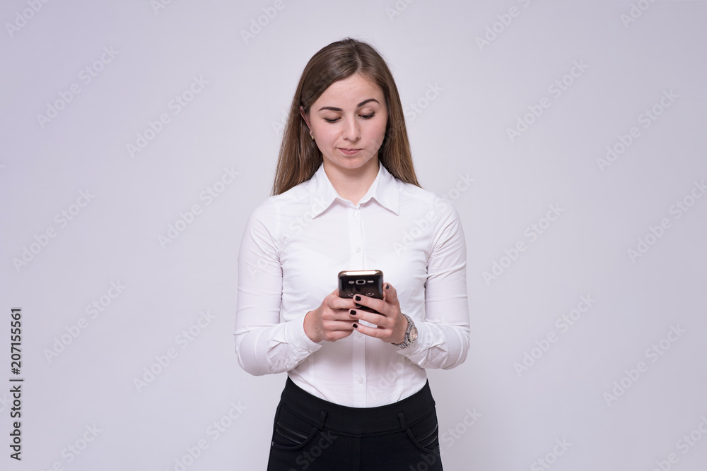 portrait of beautiful brunette girl on white background touching smartphone. portrait of beautiful brunette girl on white background touching smartphone.