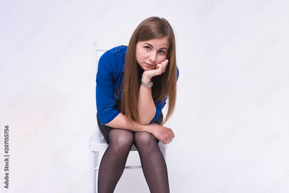 portrait of a beautiful brunette girl on a white background on a chair portrait of a beautiful brunette girl on a white background on a chair