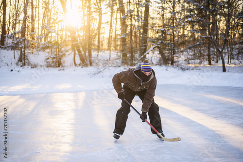 Man playing ice hockey on a frozen lake photo