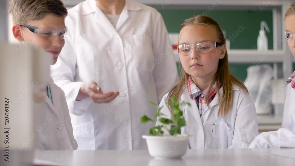 education, science and school concept - students and teacher with plant at biology class education, science and school concept - students and teacher with plant at biology class