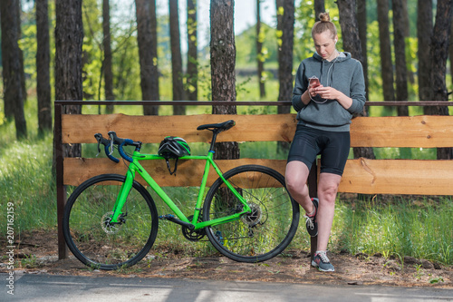 Girl on a bicycle with headphones in the park. A racing bicycle. Active way of life and playing sports.