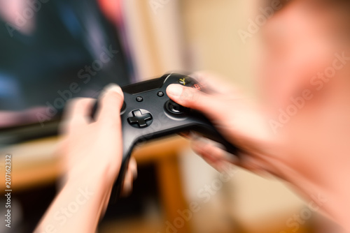 Close-up blur hands with movement pressing and holding a modern game console joystick © Stephen Davies